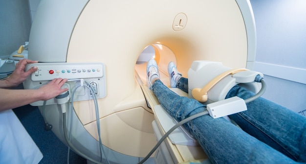 Radiolog przygotowuje pacjenta do badania kolana metodą rezonansu magnetycznego