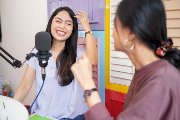 Radość Dwóch Dziewczyn śmiejących Się Podczas Rozmowy W Podcastie Za Pomocą Mikrofonu