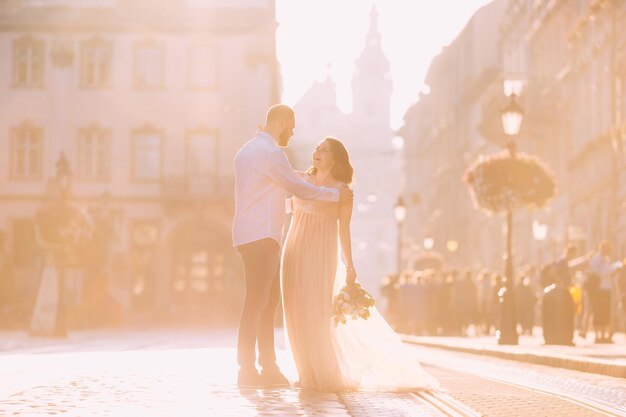 Radość eleganckich nowożeńców trzymających się za ręce uśmiecha się do siebie