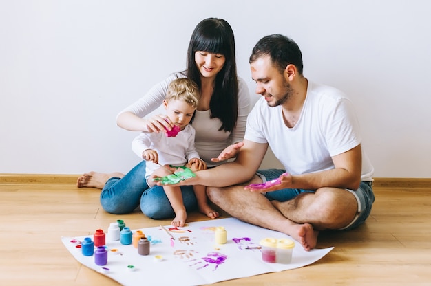 Radość rodziny sztuki szczęśliwe ojciec matka i syn pokazać ręce w jasnych kolorach farby razem