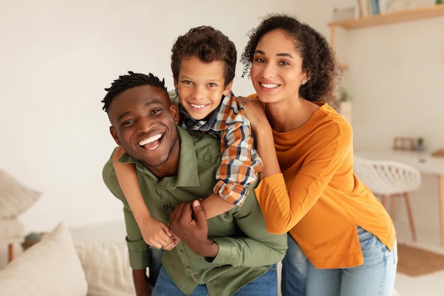 Radosni różnorodni rodzice i ich syn uściskający się w domu
