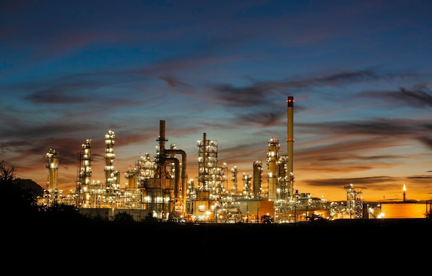 Rafineria ropy naftowej oraz instalacja i kolumna wieżowa przemysłu petrochemicznego w przemyśle naftowym i gazowym „przemysłowy z chmurą” pomarańczowy „niebo wschód słońca” w tle