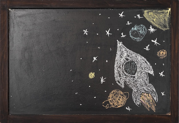 Rakieta z planetami rysowana jest na tablicy kredowej