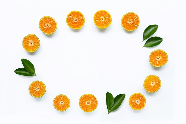 Rama wykonana ze świeżej pomarańczy z zielonymi liśćmi na białym tle