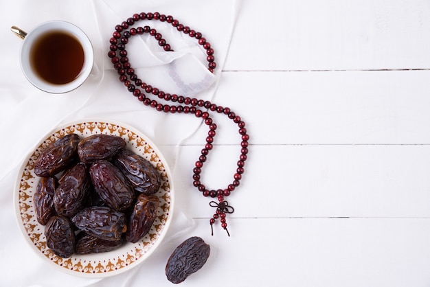 Ramadan koncepcja żywności i napojów. Różaniec drewniany, herbata i owoce daty