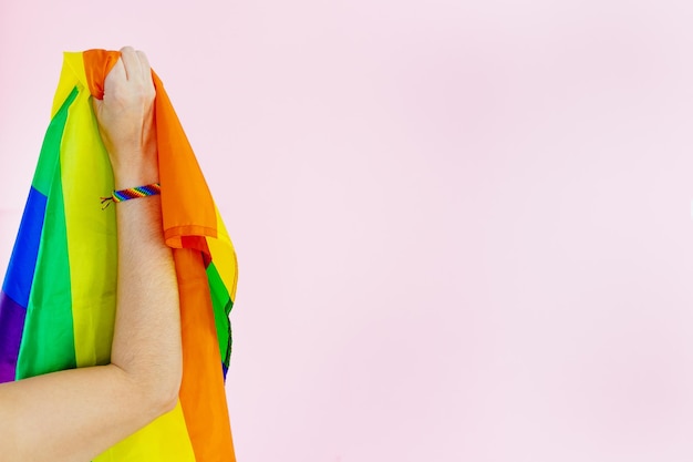 Ramię kobiety z flagą LGBTQ i bransoletką w kolorach tęczy