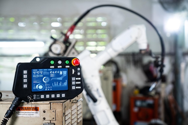 Ramię robota i jego panel adept kontrolera w warsztacie fabrycznym