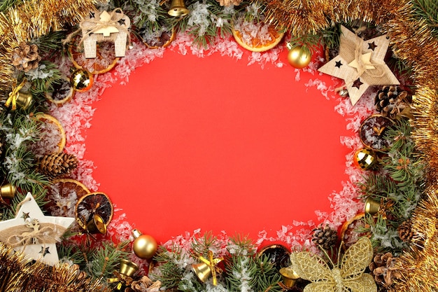 ramka z choinką i kolorowymi dekoracjami na jasnym czerwonym tle