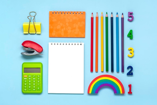 Zdjęcie ramka z materiałów szkolnych i biurowych na białym tle na niebieskim tle powrót do koncepcji edukacji szkolnej