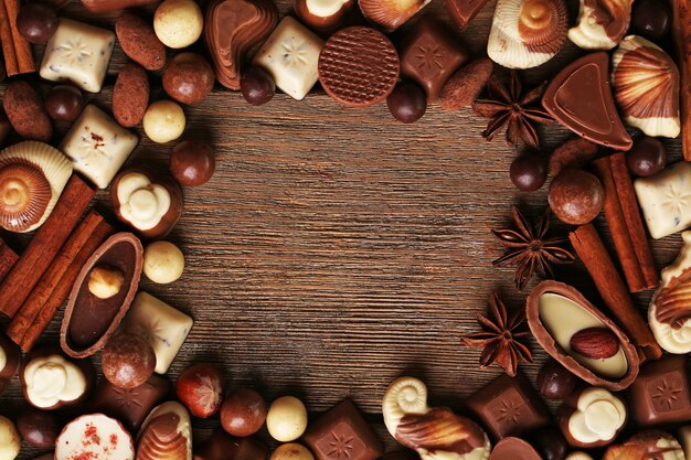Ramka z różnymi rodzajami czekoladek na drewnianym stole z bliska