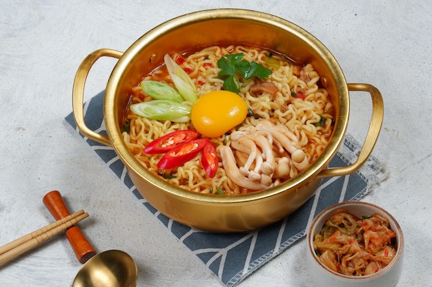 ramyoen lub Ramyun o ostrym smaku zwieńczone żółtkiem jaja, chilli, warzywami i kimchi