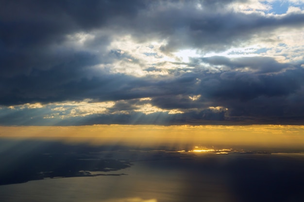 Rano wschód słońca ze skrzydłem samolotu lecącego nad oceanem.