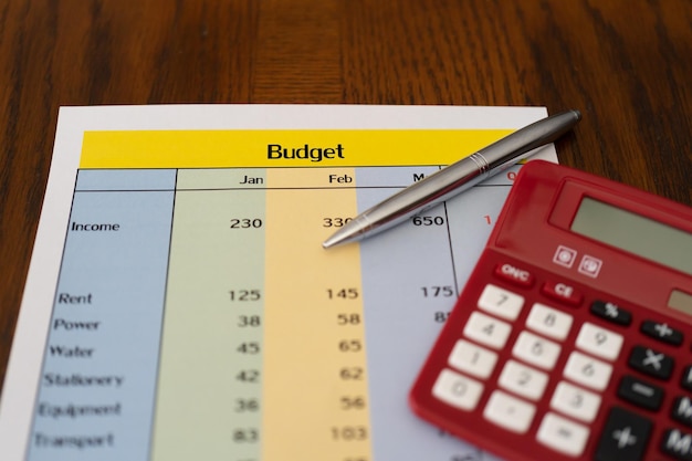 Raport budżetowy z kalkulatorem i monetami na biurowym stole
