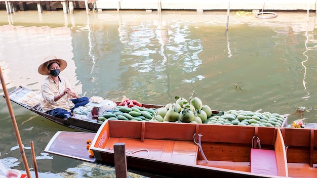 Ratchaburi Tajlandia 15 kwietnia 2022 Sprzedawcy sprzedający mango i pomelo na łodziach w starożytnym miejscu podróży Tajlandii Damnoen saduak flating market Ratchaburi Tajlandia