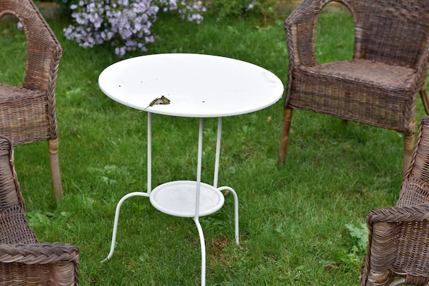 Zdjęcie rattan krzesła i biały stół w ogrodzie miejsce do palenia