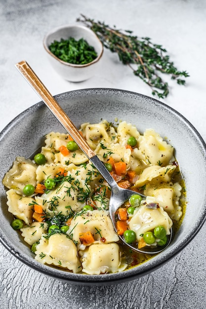 Ravioli Makaron pierogi Zupa w misce z zieleniną