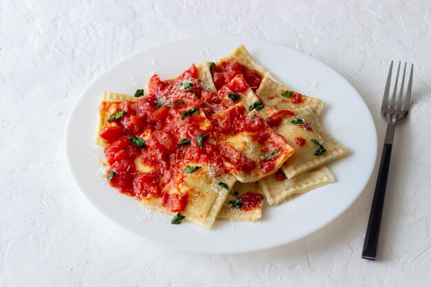 Ravioli z sosem pomidorowym, szpinakiem i parmezanem. Zdrowe odżywianie. Jedzenie wegetariańskie. Kuchnia włoska.