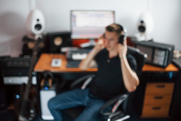 Realizator dźwięku w słuchawkach pracuje i miksuje muzykę w studiu.