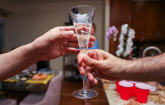 Ręce chwytają kieliszki wznosząc toast za świętowanie połączenia i rozkoszowania się alkoholem i szampanem