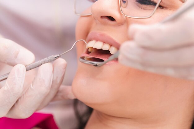 Zdjęcie ręce dentysty pracujące dla uśmiechu młodej dziewczyny
