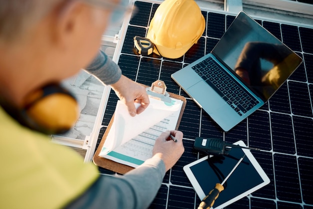 Ręce do planowania i inżynierii paneli słonecznych z listą kontrolną technologii lub ubezpieczeniem do instalacji Energooszczędny elektryk i technik energetyczny z narzędziami do laptopów i zarządzaniem konserwacją