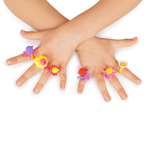 Ręce dzieci bawią się kolorowymi zabawkami biżuteryjnymi koraliki dekoracje na białym tle Pojęcie szczęścia dla dzieci
