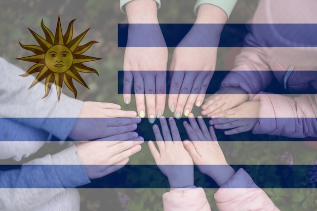 Ręce dzieci na tle flagi Urugwaju Urugwajski patriotyzm i koncepcja jedności