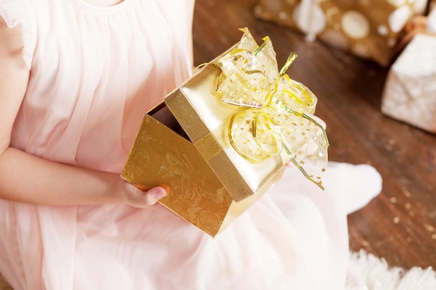 Ręce dziecka trzymające złote pudełko. Boże Narodzenie, hew rok, koncepcja urodziny.