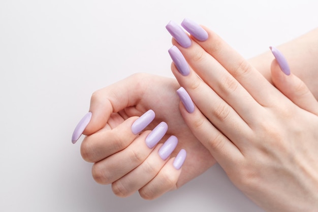 Ręce Dziewczyny Z Miękkim Fioletowym Manicure'em Na Białym Tle