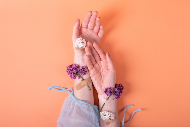 Ręce dziewczyny z plastrem medycznym z koncepcją kwiatów bzu higiena zdrowia kobiet