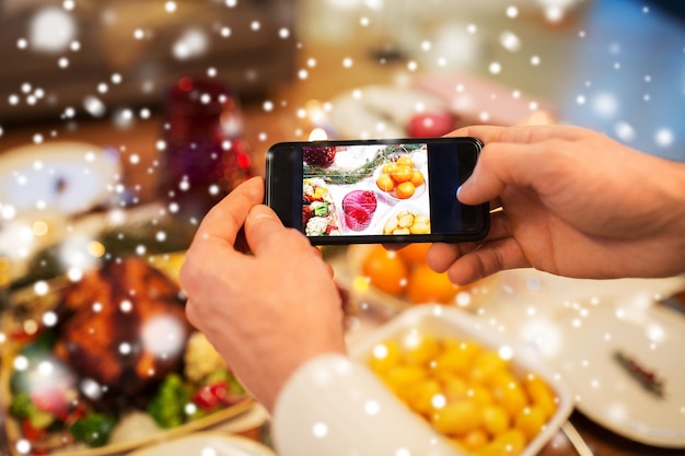 Zdjęcie ręce fotografujące jedzenie na świąteczną kolację