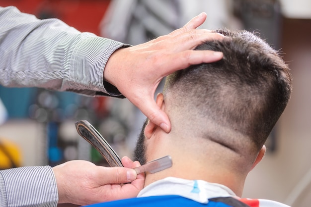 Ręce fryzjer z bliska, golenie głowy brodaty mężczyzna.