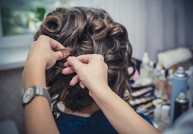 Ręce fryzjera robią fryzurę ślubną
