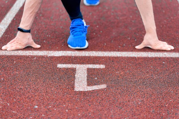 Ręce i nogi sportowców na pierwszym bieżni na stadionie