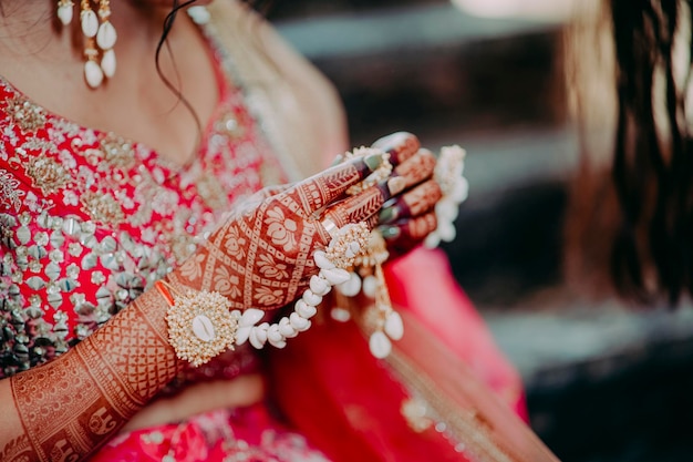 Ręce indyjskiej panny młodej są ozdobione kwiatami henny w stylu indyjskim i wzorami dłoni panny młodej