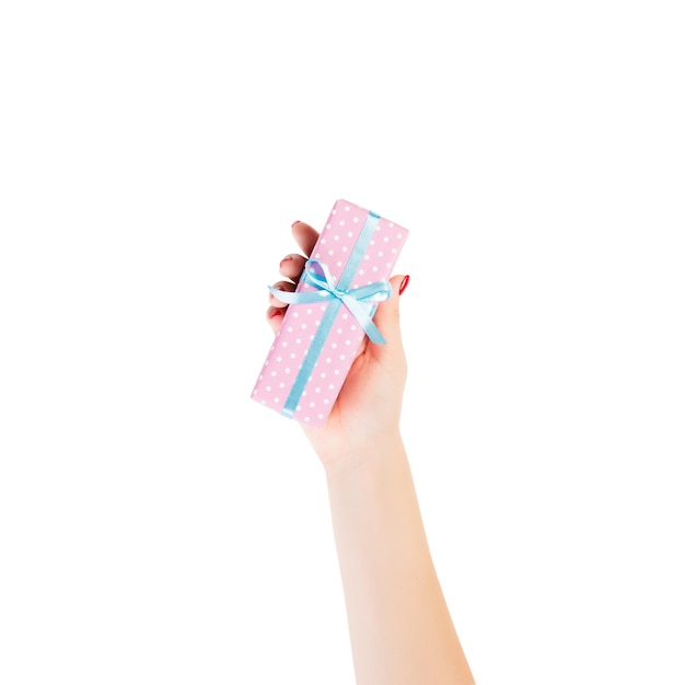Ręce kobiety dają owinięte ręcznie prezenty świąteczne lub inne świąteczne w różowym papierze z niebieską wstążką izolowane na białym tle widok z góry Święto Dziękczynienia Koncepcja pudełka na prezenty