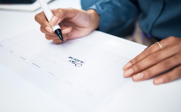 Zdjęcie ręce kobiety i znacznik na kalendarzu dla terminu podatkowego lub przypomnienia w planowaniu harmonogramu lub strategii na biurku w biurze closeup kobiety piszącej na papierze dla pamięci agendy lub planu w miejscu pracy