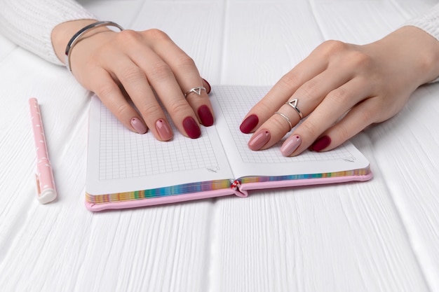 ręce kobiety z minimalistycznym różowy projekt lato manicure wiosna na stole w biurze