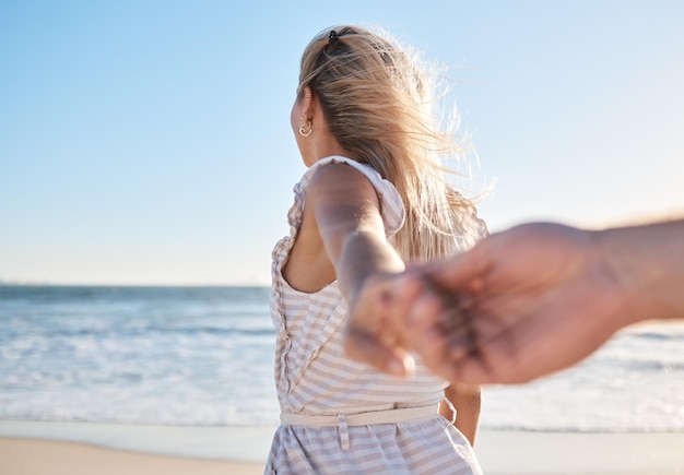 Zdjęcie ręce kochają się i spacerują z parą na plaży podczas letnich wakacji w celu romansu lub związania podróż morska i trzymanie się za ręce z kobietą prowadzącą swojego mężczyznę na spacer nad wodą oceanu na wakacjach