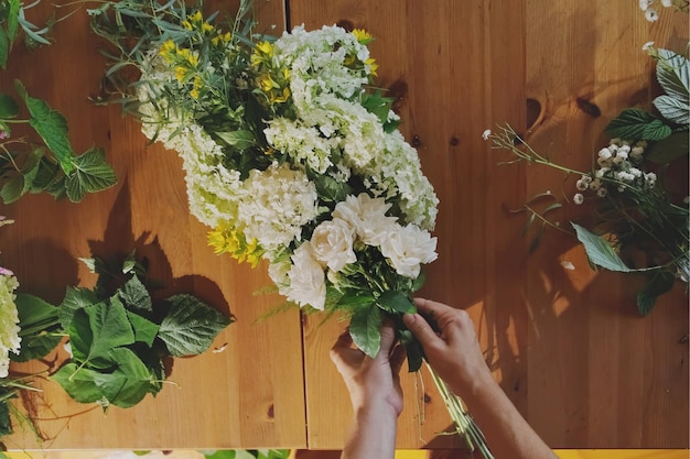 Zdjęcie ręce kwiaciarza robią piękny bukiet kwiatów.