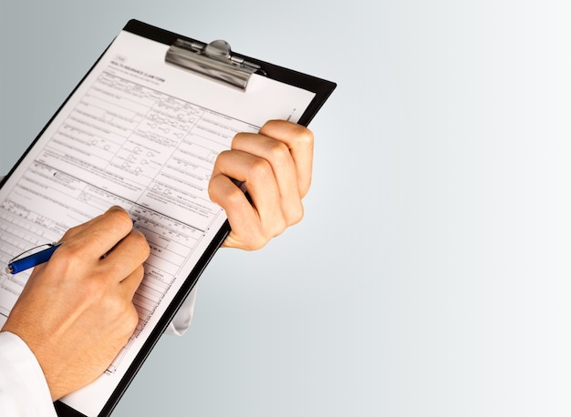 Ręce lekarza wypełniające formularz dla pacjenta