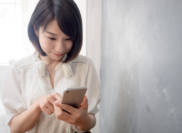 Ręce młodej azjatyckiej kobiety trzymającej telefon komórkowy