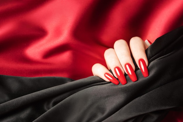 Ręce Młodej Dziewczyny Z Czerwonym I Czarnym Manicure'em Na Paznokciach