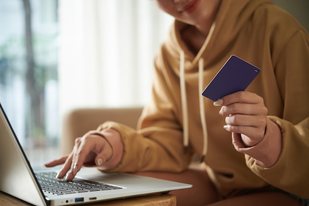 Ręce młodej kobiety robiące zakupy online i płacące za zakupy kartą kredytową