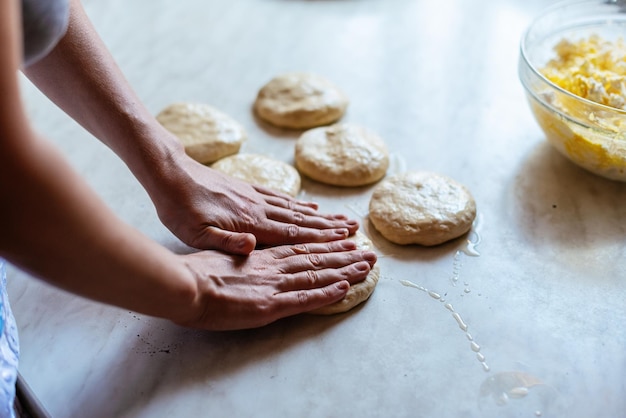 Ręce młodej kobiety wyrabiającej ciasto na chleb lub pizzę w domu Produkcja produktów mącznych Wyrabianie ciasta kobiecymi rękami