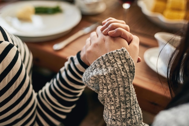 Zdjęcie ręce modlą się i rodzina przy stole o błogosławieństwo żywności i wdzięczność przed wspólnym posiłkiem w domu dłoń trzymająca uwielbienie i ludzi modlących się przed jedzeniem modlitwy i szacunku religijnego