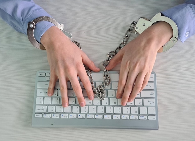 Zdjęcie ręce nastolatków na klawiaturze komputera w kajdankach