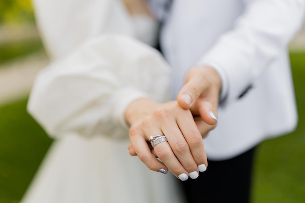Ręce nowożeńców z pierścionkami po ceremonii malowania Pan młody z panną młodą