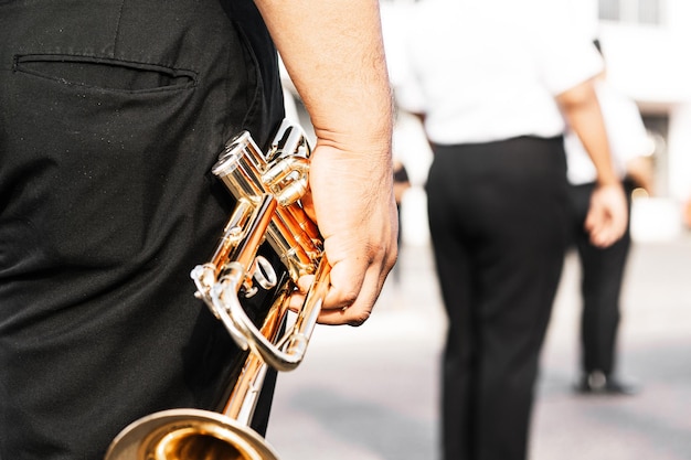 Zdjęcie ręce osoby trzymającej muzykę na trąbce i koncepcję orkiestry marszowej