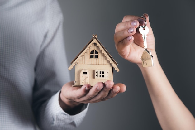 Ręce pary rodzinnej trzymającej model domu i klucz